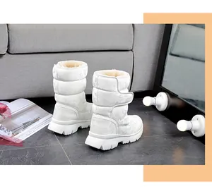 Side view of white camo snow boots with warm lining and Velcro closure