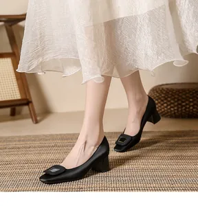 Elegant black satin chunky heel pumps with square toe and decorative buckle on model.