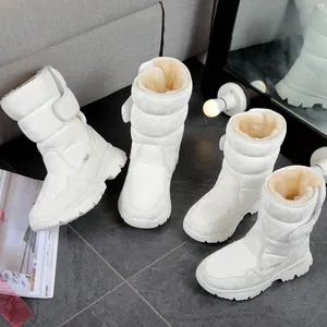 Detailed view of white waterproof snow boots with thick plush lining and non-slip soles.