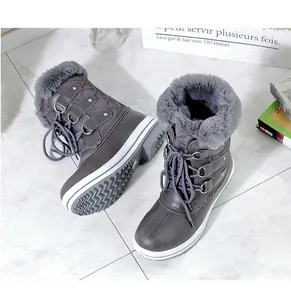 Détail des bottes de neige d'hiver grises avec bordure en fausse fourrure.
