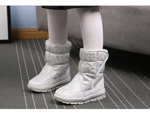 Detailopname van witte glitterende sneeuwlaarzen voor kinderen met warme wollen voering.