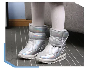 Close-up van holografische zilveren sneeuwlaarzen voor kinderen met witte panty's