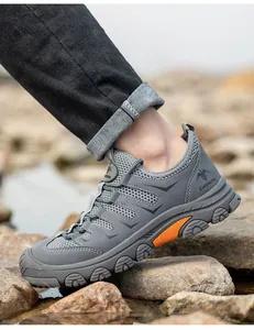 Detail view of grey breathable safety work shoe with steel toe protection on rocks