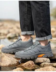 Detail shot of breathable grey safety work shoes for men on rugged outdoor rocks