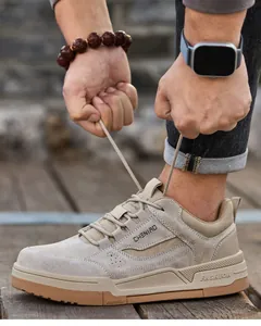 Primer plano de un zapato de seguridad caqui con punta de acero atado por un hombre afuera.