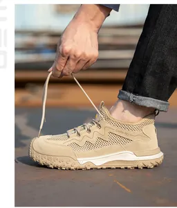 Gros plan de chaussures de sécurité respirantes beiges sur un chantier industriel