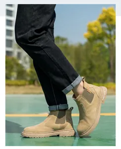 Detalle de botas de seguridad Chelsea beige para hombre usadas al aire libre con jeans.
