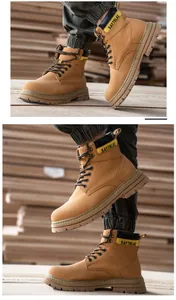 Detail view of durable camel safety work boots with anti-slip rubber soles on wood