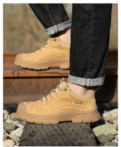 Vista lateral de botas de seguridad para hombre color arena en una vía de tren