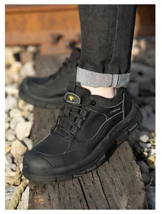 Primer plano de zapatos de seguridad negros con punta de acero en un entorno ferroviario.