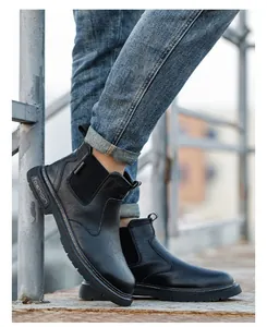 Vista detallada de botas de seguridad Chelsea negras para hombres en superficie metálica