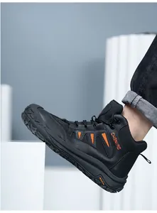 Detalle de la bota de trabajo de seguridad de cuero negro con acentos de color naranja vivo