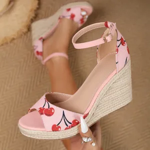 Detailansicht der rosa Keilsandale mit Kirschdruck, Espadrille-Plateau und Fesselriemen
