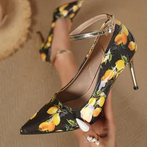 Elegant detail of lemon print stiletto high heels with golden ankle strap and buckle