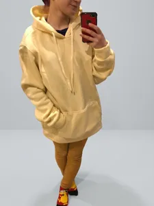 Detailed mirror selfie showing the fit of a yellow casual oversized hooded sweatshirt