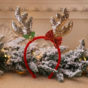 Close-up of golden glitter reindeer antler headband with a red bow and festive bell.
