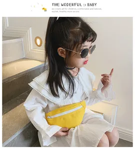 Sac banane en toile jaune tendance pour enfants porté par une fille en robe blanche