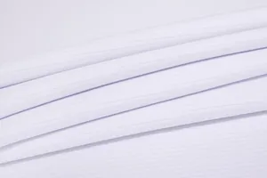 Macro view of premium white breathable ribbed fabric texture for functional sports apparel
