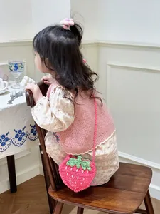 Schattige handgemaakte gehaakte aardbeitas voor meisjes in een gezellige setting