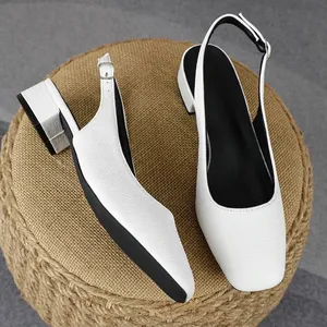 Dettaglio di scarpe slingback bianche a punta quadrata con tacco largo 3 cm su sgabello