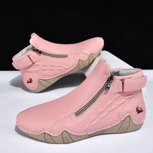 Detalle de botines rosas para hombre con cremallera lateral y acabado texturizado.