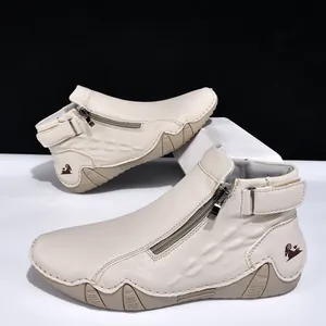 Detalle de botines beige para hombre con cremallera lateral y cuero texturizado.