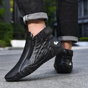 Detalle de botas Martin de cuero negro con cremallera lateral y textura de cocodrilo.