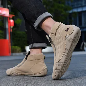 Detalle de botas Martin altas de gamuza beige para hombre con cremallera lateral y logo