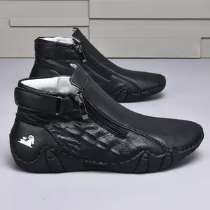 Detalle de botines de cuero negro con cremallera lateral y patrón de escamas.