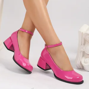 Détail de chaussures Mary Jane en cuir verni rose vif avec talons blocs et brides cheville.