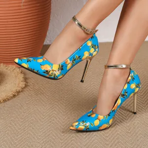Macro view of fashionable blue high heels with lemon print and gold stiletto heels.