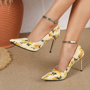 Detailed view of lemon print pointed toe stiletto heels with gold ankle straps.