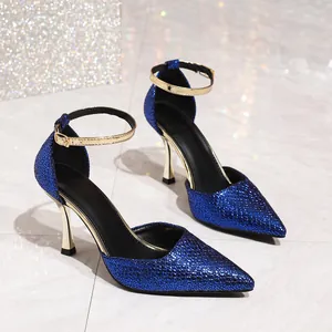 Detailed side view of blue glitter pointed-toe high heels with gold ankle straps.