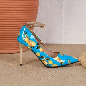 Detailed side view of bright blue pointed-toe stiletto heels featuring lemon fruit print