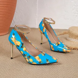 Detail shot of blue pointed-toe high heels with a vibrant lemon print and gold ankle straps.