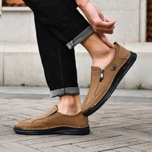 Detail of men's brown leather casual loafers with handmade stitching and side zipper