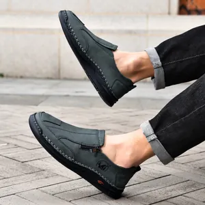 Close-up of men's dark green hand-stitched leather loafers with zipper detail