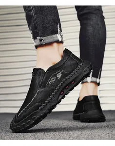 Vue de côté de mocassins en cuir noir faits main avec coutures contrastées et semelle épaisse