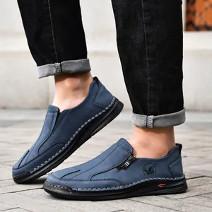 Macro shot of blue men's leather shoes featuring decorative handmade stitching and zipper