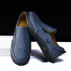 Detailed view of blue hand-stitched leather loafers with decorative side zipper