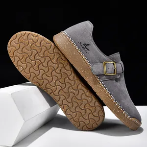 Detalle de mocasines de ante gris con suela de goma antideslizante y costuras blancas