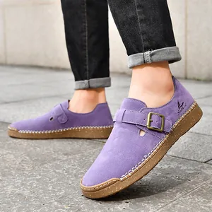 Zuecos planos de ante morado con hebilla ajustable y suela de goma blanda.