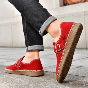 Primer plano de mocasines planos de gamuza roja con detalle de hebilla y suela.