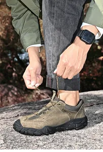 Gros plan de chaussures de randonnée en cuir de porc lacées dans un décor extérieur rocheux