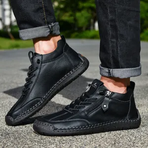 Close-up detail of black leather men's Martin boots with side zipper and stitching