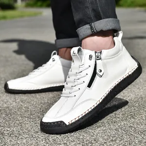 Detail of white leather men's boot showing black side zipper and hand-stitched sole.