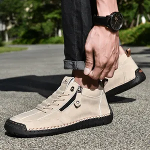 Close-up of men's beige suede Martin boots with side zipper and hand-stitched sole.