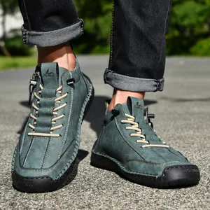 Close-up of men's teal Martin boots showing side zipper detail and rugged rubber soles