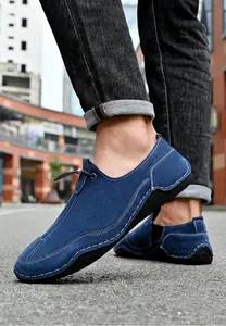 Close-up view of stylish blue suede men's casual outdoor shoes with white stitching