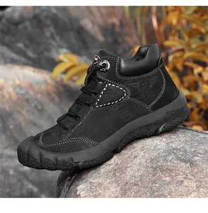 Detailopname van zwarte leren hoge outdoor wandelschoenen met stevige gripzool